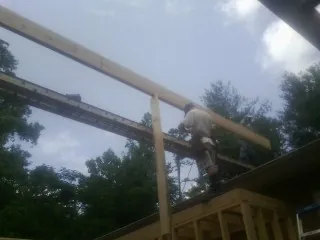 Carpenter setting a ridge beam over a new addition frame — Ice Dam Removal by Roofing Brothers in Bunker Hill