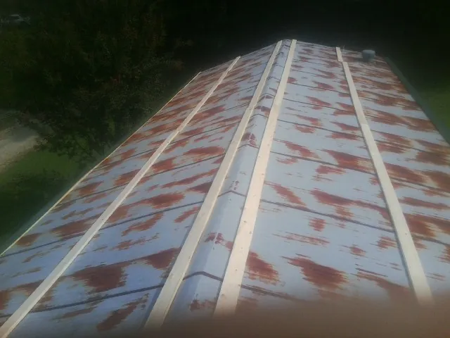 Rusted metal roof panels with new wood purlins before replacement — Storm Damage Roof Repair in Bunker Hill by Roofing Brothers
