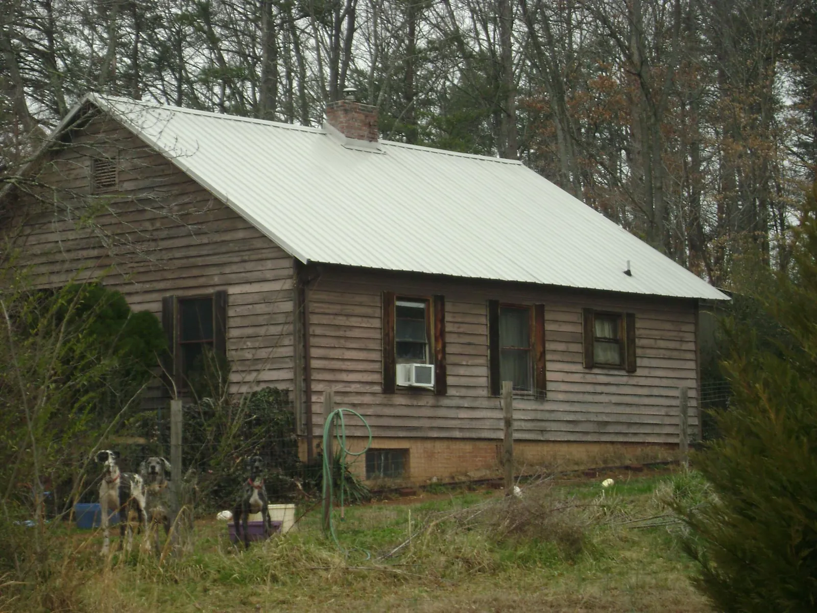 White metal roof on an old wood sided farmhouse, from a Metal Roof Installation job in Bunker Hill
